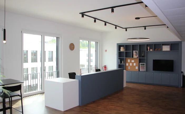 Empfangsbereich der SEO-Agentur Regensburg mit moderner Theke, Sitzbereich und großen Fensterflächen
