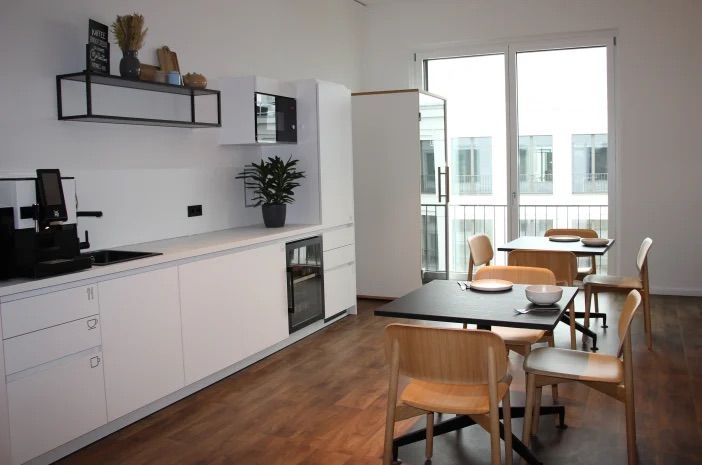 Moderne Büroküche mit Essbereich, Fensterfront und heller Ausstattung